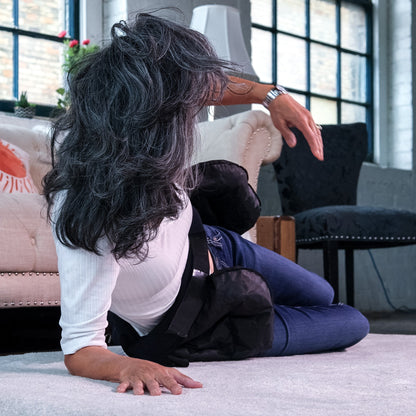 Woman starting to sit up after falling while the Smart Hip Guardian belt begins to deflate